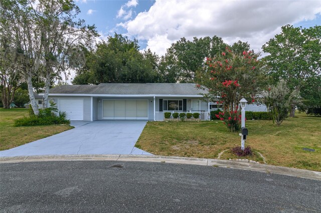 ranch-style house featuring covered porch, a garage, and a front lawn