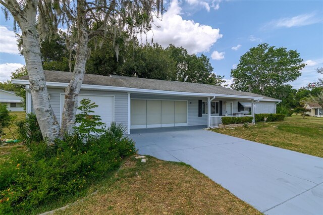 ranch-style home featuring covered porch, a garage, and a front yard