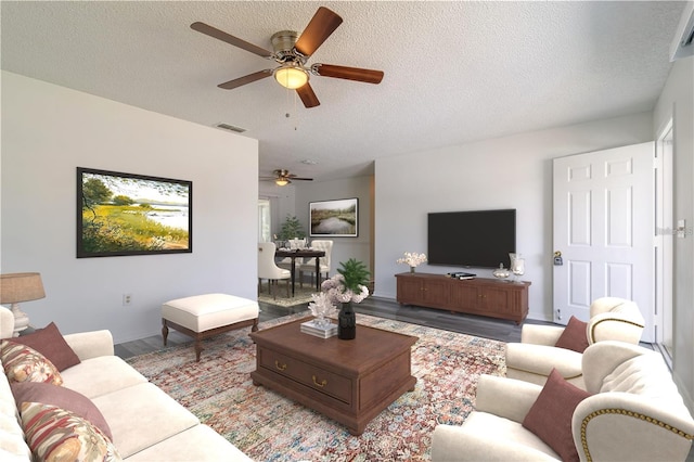 living room with a textured ceiling and ceiling fan