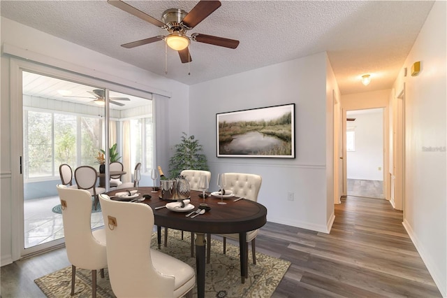 dining space with baseboards, a textured ceiling, wood finished floors, and a ceiling fan