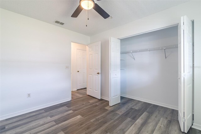 unfurnished bedroom with dark hardwood / wood-style flooring, ceiling fan, a closet, and a textured ceiling