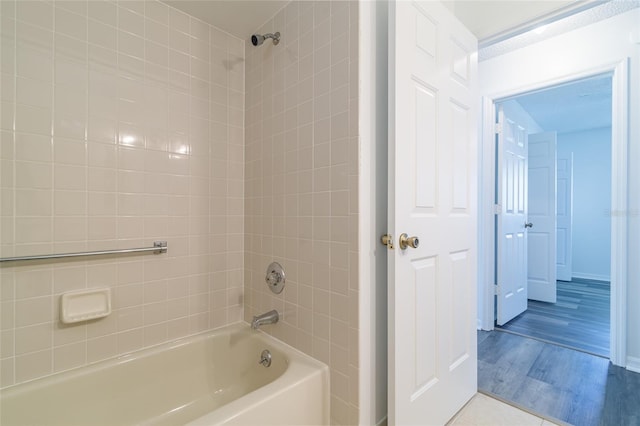 bathroom featuring shower / washtub combination, wood finished floors, and baseboards