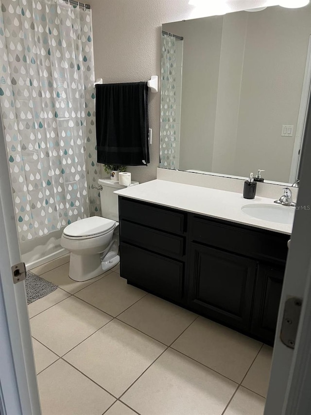 bathroom with toilet, vanity, tile patterned flooring, and a shower with curtain