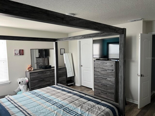 bedroom with dark hardwood / wood-style floors and a textured ceiling