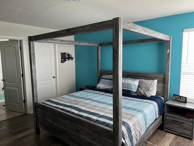 bedroom featuring hardwood / wood-style floors and a textured ceiling