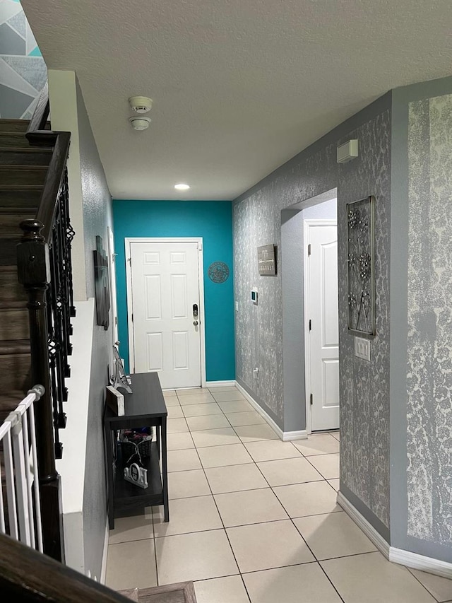 foyer with a textured ceiling and light tile floors