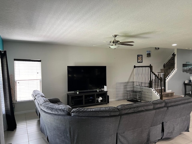 living room with ceiling fan, a textured ceiling, and tile floors