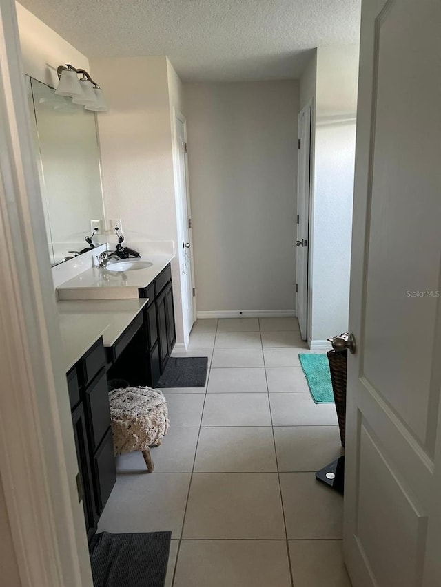 bathroom featuring tile floors, vanity with extensive cabinet space, and a textured ceiling