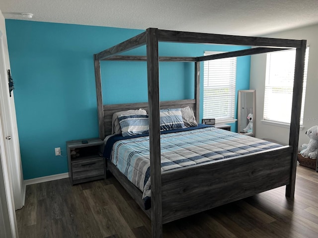 bedroom featuring a textured ceiling and dark wood-type flooring