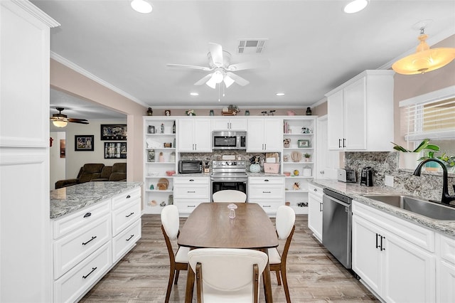 kitchen with stainless steel appliances, light stone countertops, ceiling fan, and backsplash