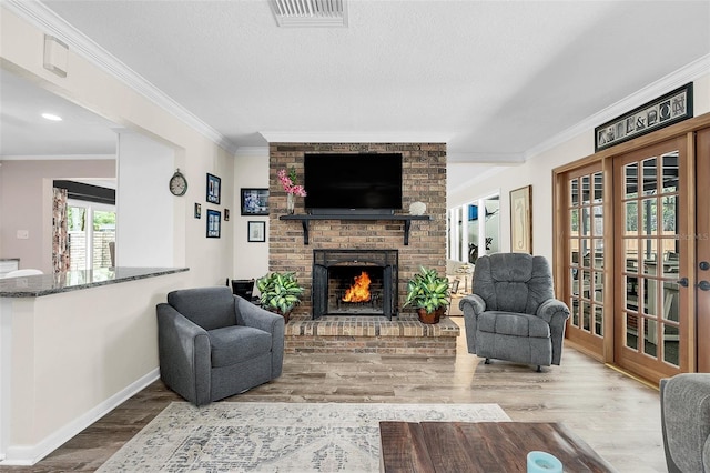 living room with crown molding, a textured ceiling, a fireplace, and wood-type flooring