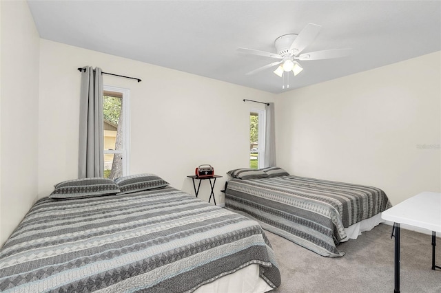 carpeted bedroom with ceiling fan and multiple windows