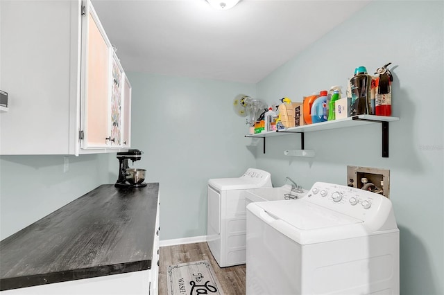 washroom featuring wood-type flooring, cabinets, washer hookup, and washer and clothes dryer