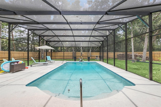 view of pool with a patio area, glass enclosure, and a lawn