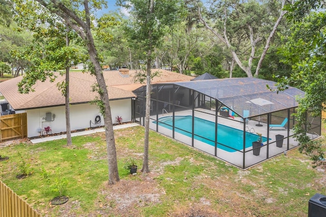 view of pool with glass enclosure and a patio area