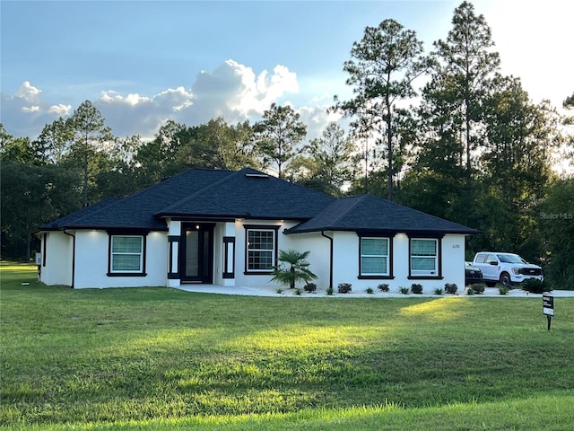 view of front facade with stucco siding and a front lawn