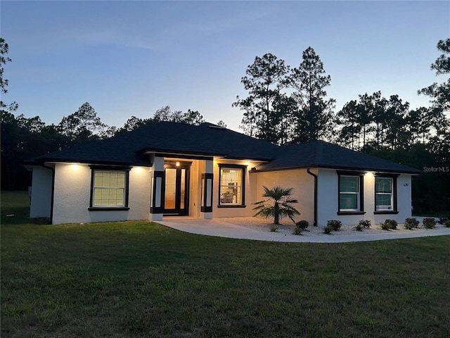 view of front of house with stucco siding and a front yard