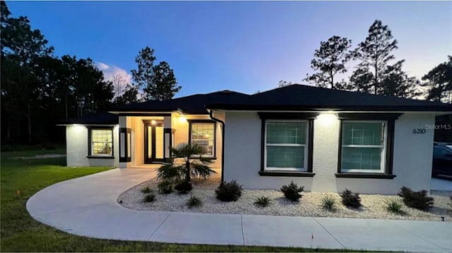 view of front of home with a front lawn and stucco siding