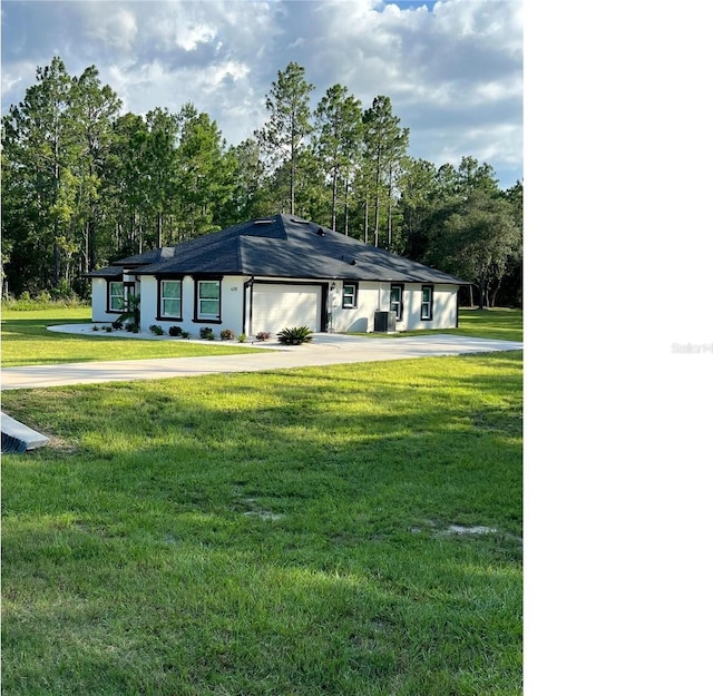 view of front of property featuring a front lawn, concrete driveway, and an attached garage