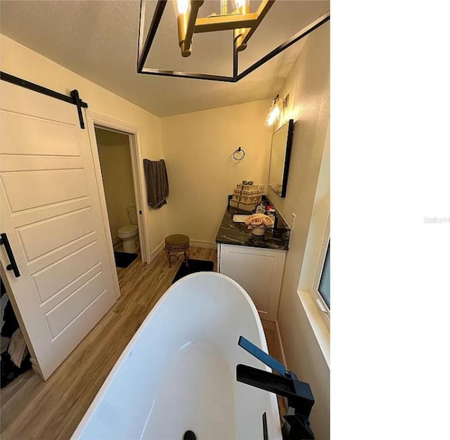 bathroom featuring sink, toilet, hardwood / wood-style floors, and a tub