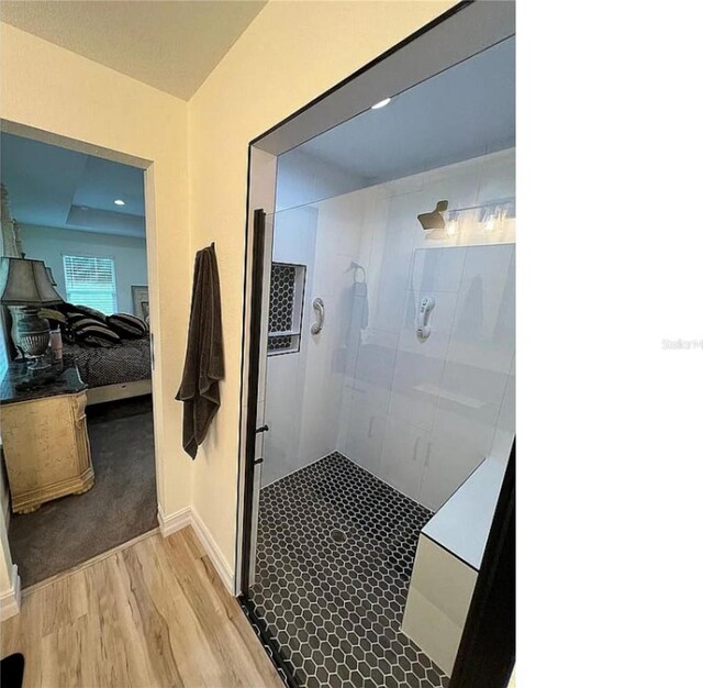 bathroom featuring tiled shower and hardwood / wood-style flooring