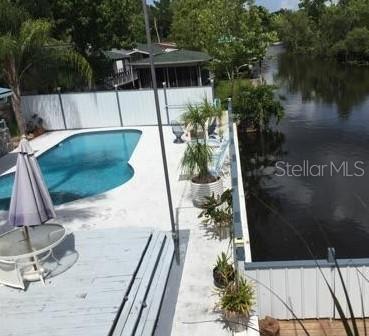 view of swimming pool featuring a patio area and a water view