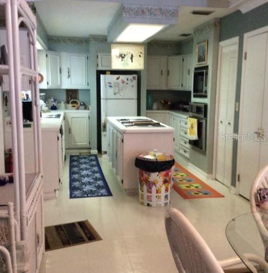 kitchen featuring oven, white fridge, cooktop, and built in microwave