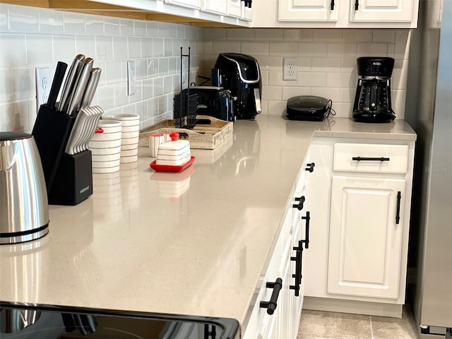 kitchen featuring decorative backsplash and white cabinetry