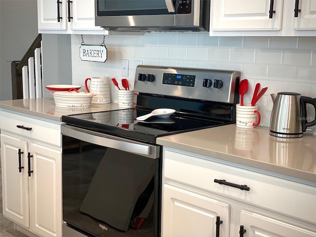 kitchen featuring white cabinets, appliances with stainless steel finishes, and tasteful backsplash