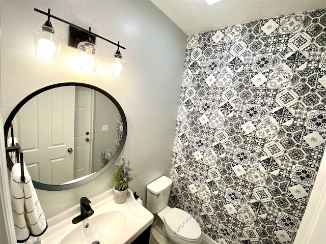 bathroom with vanity, a textured ceiling, and toilet