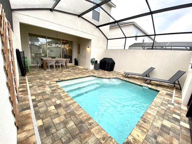 view of swimming pool featuring a patio and a lanai