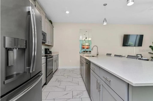 kitchen with appliances with stainless steel finishes, decorative light fixtures, gray cabinetry, and sink