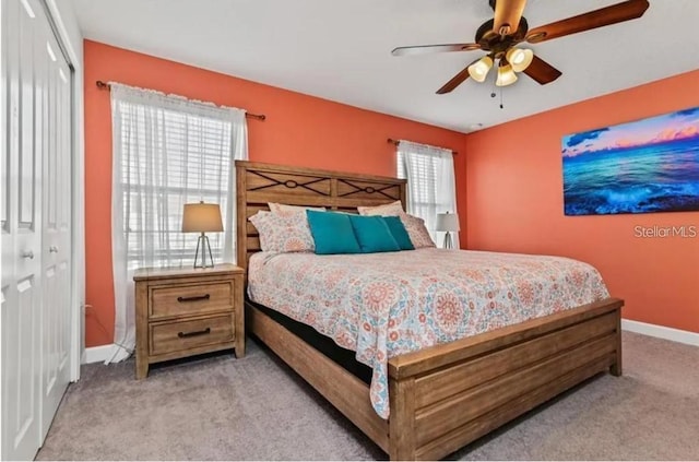 bedroom with ceiling fan, a closet, light colored carpet, and multiple windows