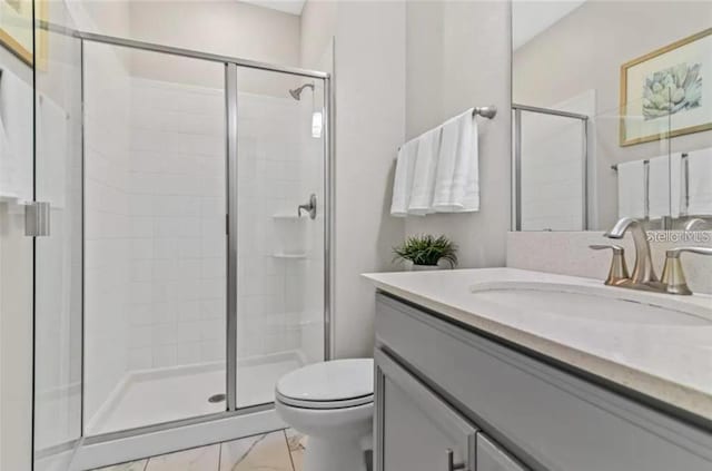 bathroom with vanity, toilet, and a shower with shower door