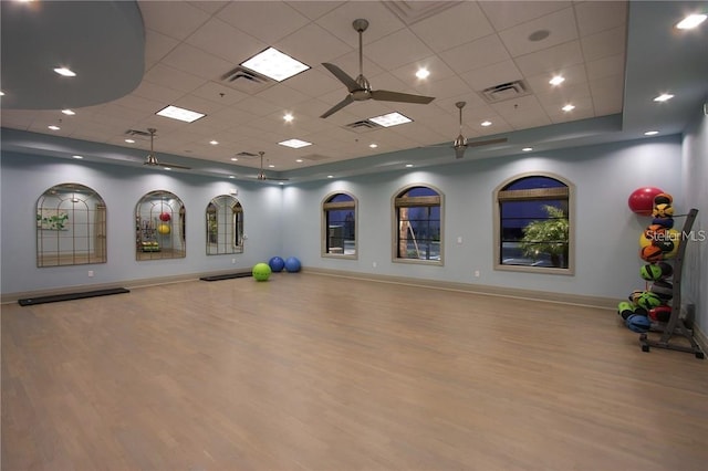 workout room featuring a paneled ceiling, ceiling fan, and light hardwood / wood-style floors