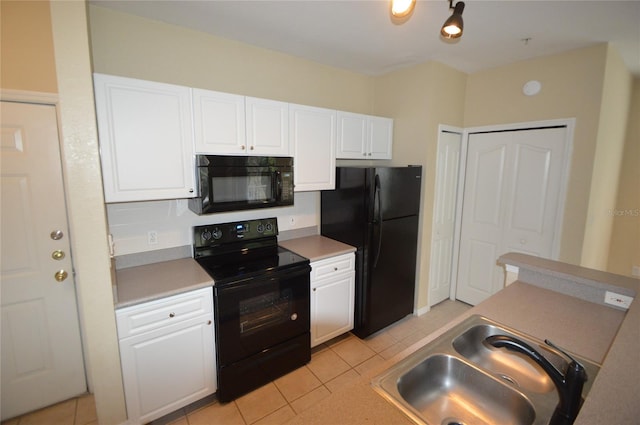 kitchen with white cabinets, a sink, black appliances, and light tile patterned floors