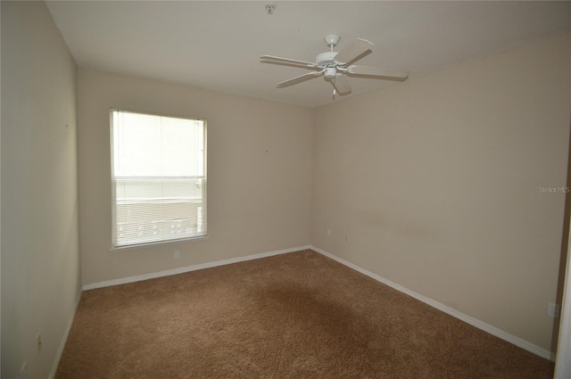 carpeted empty room with baseboards and a ceiling fan