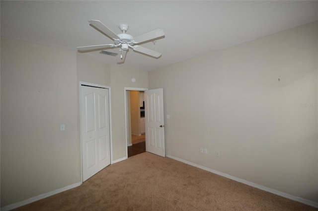 unfurnished bedroom with carpet floors, a closet, visible vents, ceiling fan, and baseboards