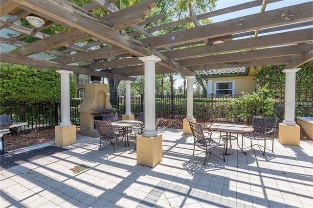 view of patio / terrace with fence, exterior fireplace, a pergola, and outdoor dining space