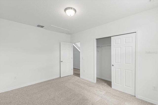 unfurnished bedroom featuring light carpet and a closet