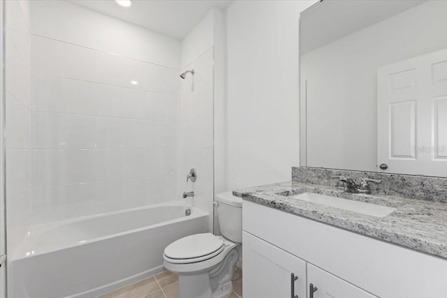 full bathroom with tiled shower / bath, vanity, toilet, and tile patterned floors