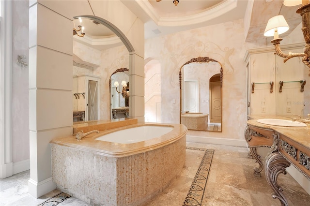 bathroom with vanity, crown molding, a tray ceiling, and a bathing tub