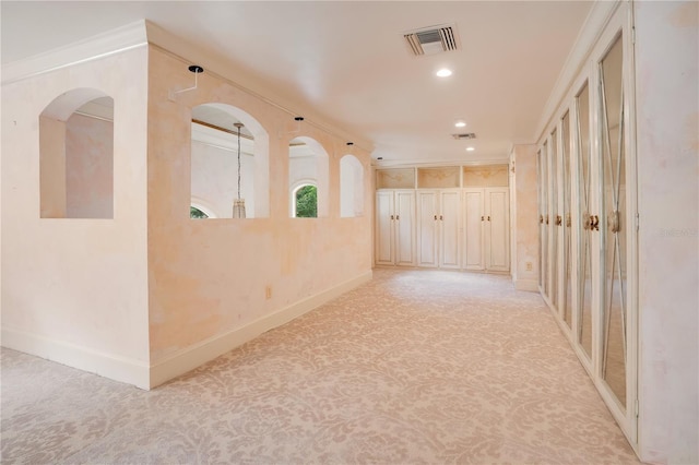 hall with light carpet and ornamental molding