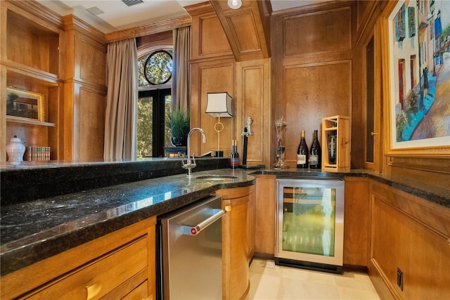 bar with wine cooler, sink, and dark stone counters