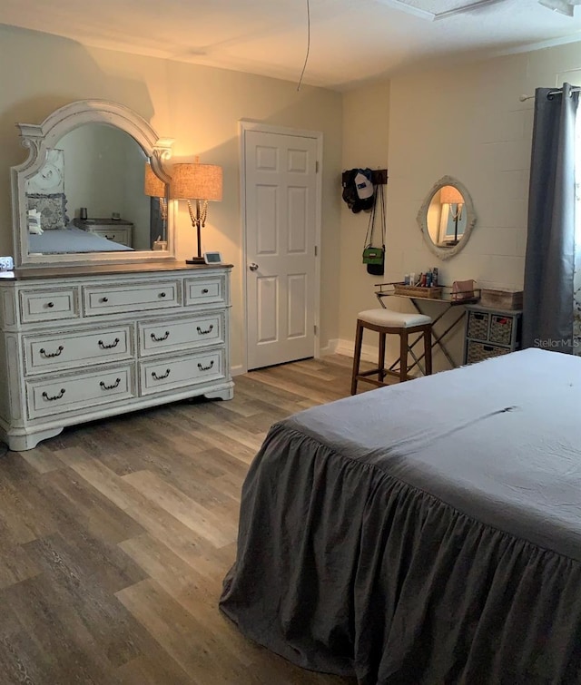 bedroom featuring light wood finished floors and baseboards