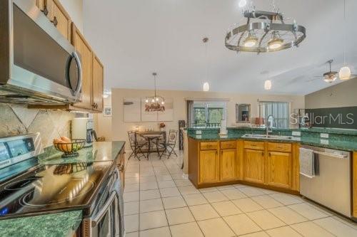 kitchen with dark countertops, stainless steel appliances, a sink, and decorative light fixtures