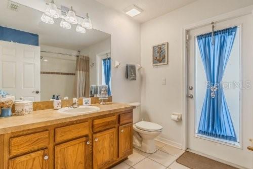 full bathroom with vanity, curtained shower, tile patterned flooring, and toilet