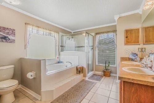 bathroom with tile patterned floors, crown molding, and a bath