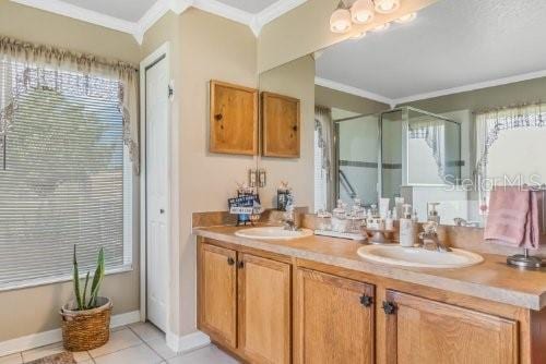 bathroom with ornamental molding, an enclosed shower, a sink, and double vanity