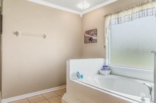 full bathroom featuring crown molding, baseboards, a bath, and tile patterned floors